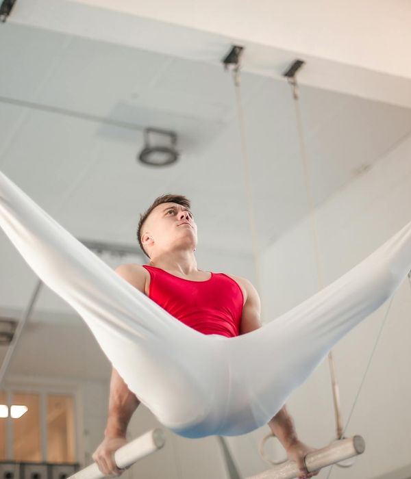 Man performing a controlled strength exercise in a dark, focused environment.