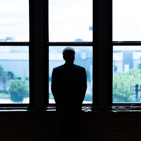Silhouette of a man in a balancing pose against a minimalist background.